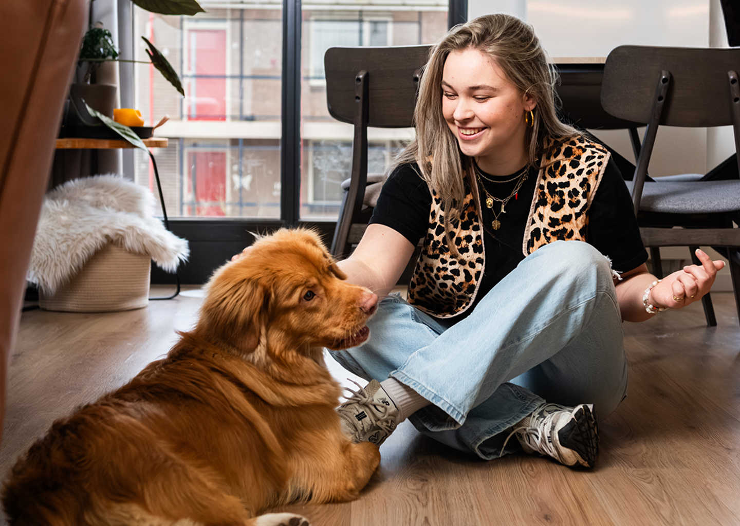 Meisje zit op vloer met hond