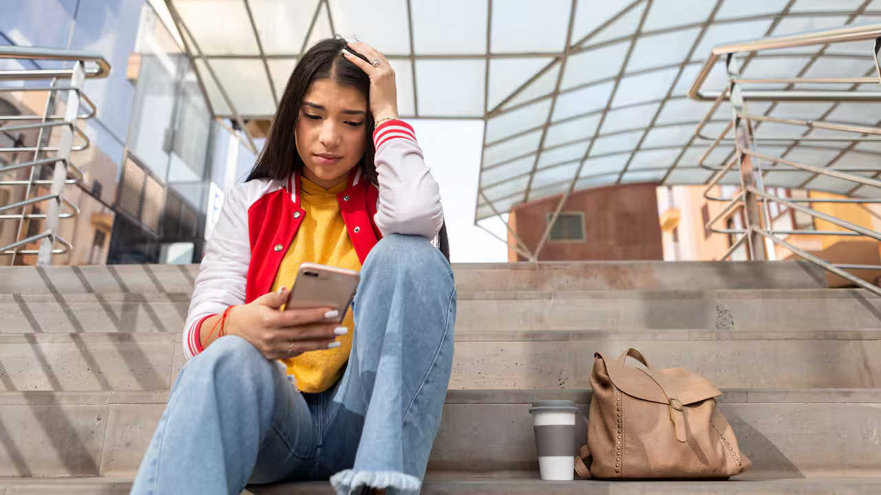 Meisje met hand in haar op mobiel