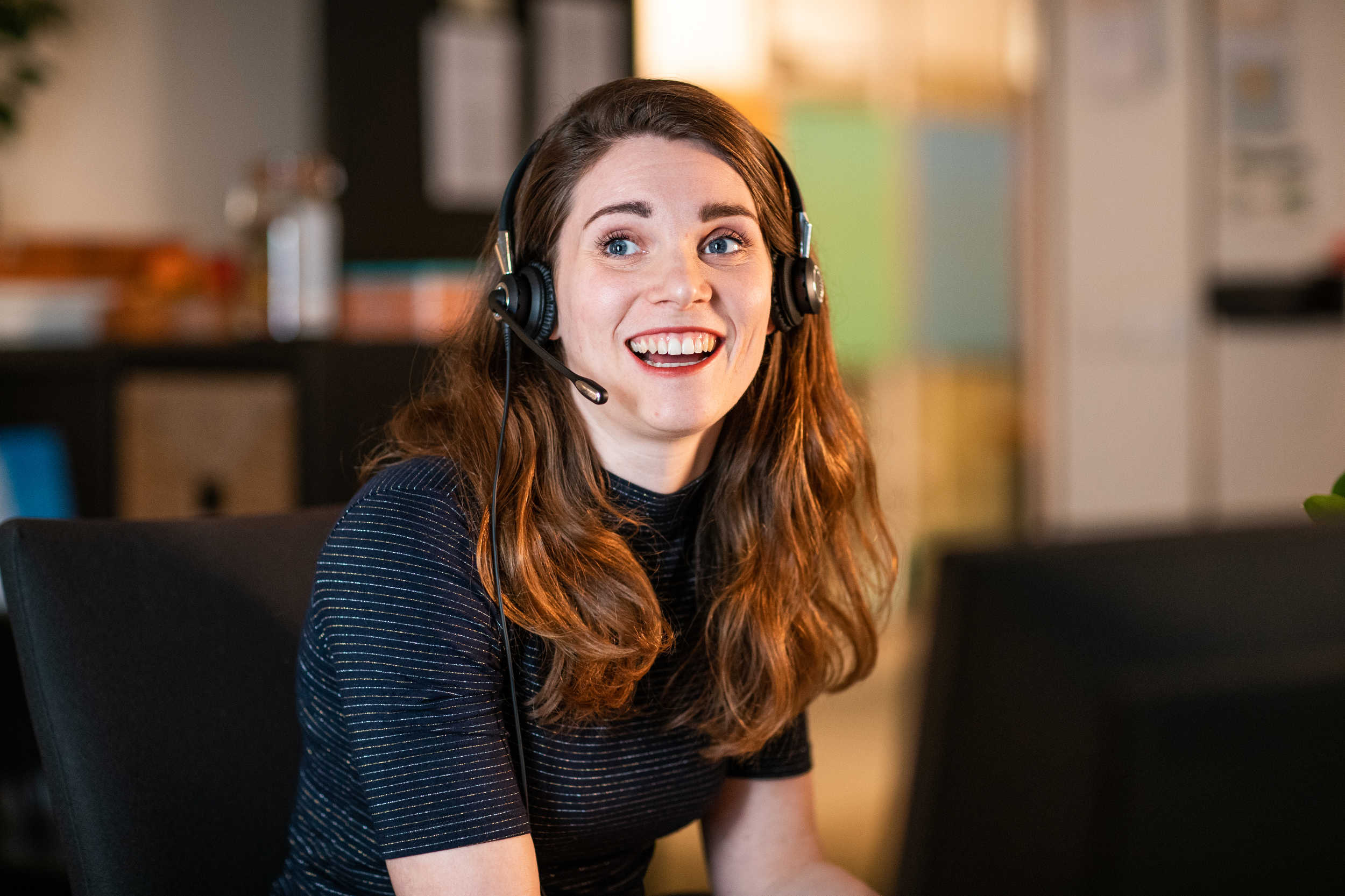 Kindertelefoon vrijwilliger praat via headset achter computer